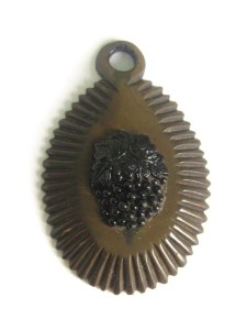 photo shows a large pendant, it is opaque brown, with scalloped edges, the centre is a glued on motiff of grapes, made from molded black glass